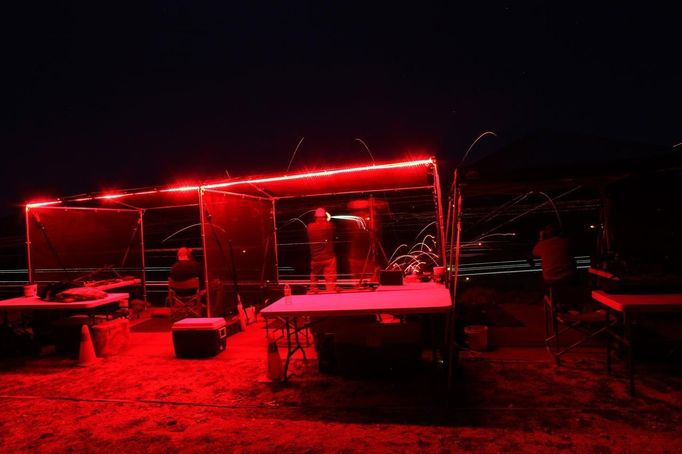 Shooters fire their weapons as tracers streaks are illuminated at night during the Big Sandy Shoot in Mohave County, Arizona March 22, 2013. The Big Sandy Shoot is the largest organized machine gun shoot in the United States attended by shooters from around the country. Vintage and replica style machine guns and cannons are some of the weapons displayed during the event. Picture taken March 22, 2013. REUTERS/Joshua Lott (UNITED STATES - Tags: SOCIETY) Published: Bře. 25, 2013, 3:34 odp.