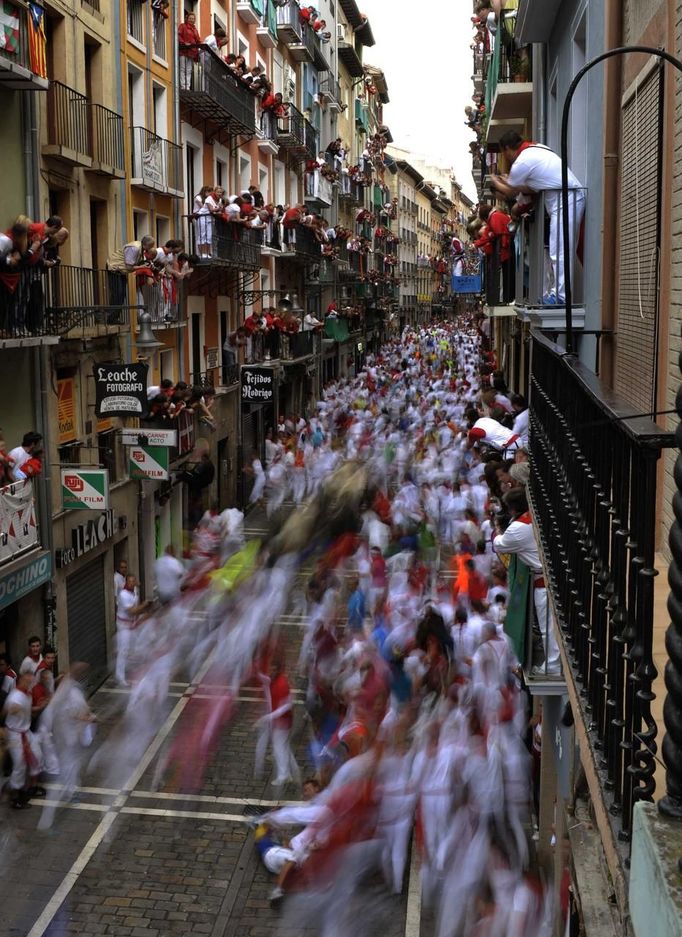 Runners sprint alongside Fuente Ymbro fighting bulls on Estafeta street during the fifth running of the bulls at the San Fermin festival in Pamplona July 11, 2012. Several runners suffered light injuries in a run that lasted three minutes and twelve seconds, according to local media. REUTERS/Vincent West (SPAIN - Tags: ANIMALS SOCIETY) Published: Čec. 11, 2012, 9:38 dop.