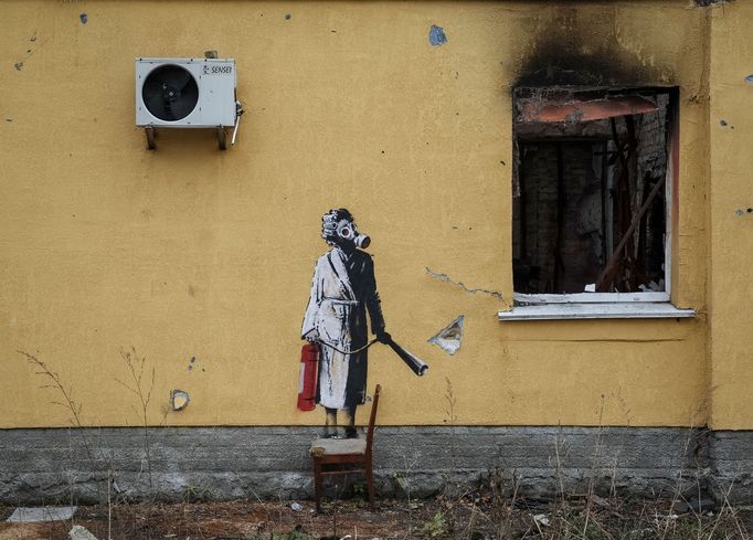 Žena v županu s natáčkami ve vlasech a v plynové masce s hasicím přístrojem, taktéž od Banksyho.