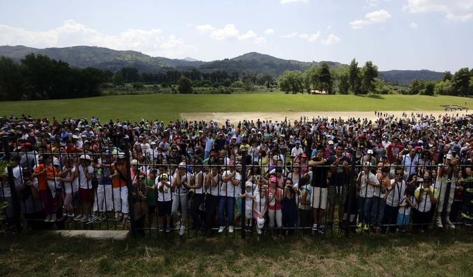 Spectators watch as Alexander Loukos (unseen), British boxer of Greek descent, runs with the Olympic flame during the Olympic torch relay at the site of ancient Olympia in Greece May 10, 2012. REUTERS/Kevin Coombs (GREECE - Tags: SPORT OLYMPICS) Published: Kvě. 10, 2012, 11:10 dop.