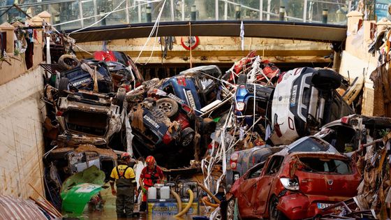 Auta na hromadě v oranžovém bahně. Snímky ukazují zkázu po povodních ve Španělsku