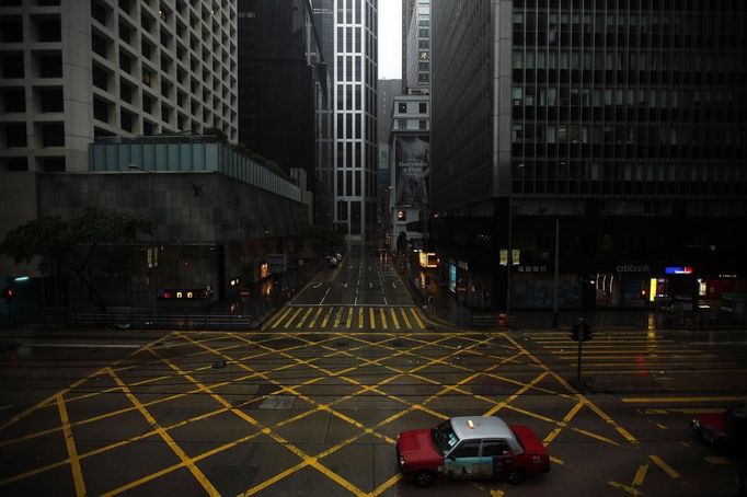 A taxi drives across an empty street in Hong Kong's business central district as Typhoon Vicente approaches July 24, 2012. Hong Kong raised its highest tropical cyclone warning on Tuesday as an intensifying severe typhoon edged closer towards the financial hub, grounding flights and forcing the port to close.Financial markets, schools, businesses and non-essential government services close when any No. 8 or above signal is hoisted, posing a disruption to business in the capitalist hub and former British colony that returned to Chinese rule in 1997. REUTERS/Tyrone Siu (CHINA - Tags: ENVIRONMENT DISASTER) Published: Čec. 24, 2012, 12:58 dop.