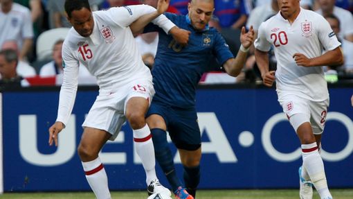 Joleon Lescott a Alex Oxlade-Chamberlain se snaží zabránit Karimovi Benzemovi v kontaktu s míčem během utkání Francie - Anglie v základní skupině D na Euru 2012.