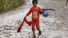 A child jockey walks on the track at Panda racecourse outside Bima, November 17, 2012. Dozens of child jockeys, some as young as eight-years-old take part in the races. Involving nearly 600 horses they take place around a dusty, oval track of 1,400 meters (nearly one mile). The reward, for the winner is a handful of cash for his family, and glory for the jockey. The grand prize is one million rupiah ($100). Those who win their groups get two cows. The chairman of the races' organising team, Hajji Sukri, denies that there is any danger to the children saying they are all skilful riders and none has been killed or seriously hurt. Picture taken November 17, 2012. REUTERS/Beawiharta (INDONESIA - Tags: SPORT SOCIETY) ATTENTION EDITORS: PICTURE 20 of 25 FOR PACKAGE 'BETTING ON CHILD JOCKEYS' Published: Lis. 24, 2012, 9:16 dop.