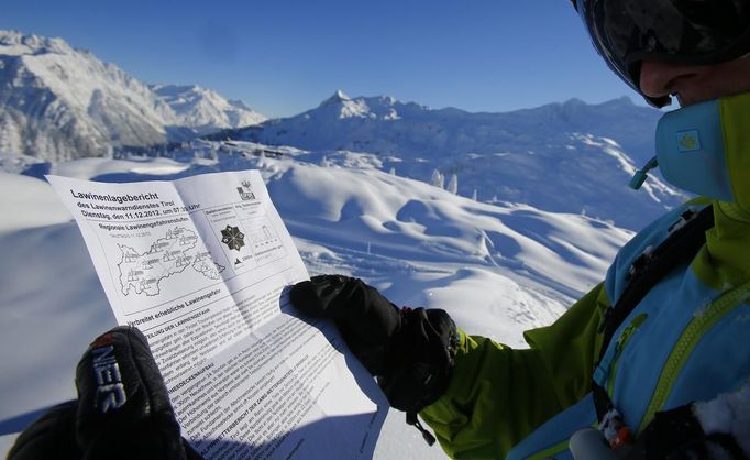 Austrian freeride skier Mathias Haunholder (R) checks the avalanche risk report prior to a freeride skiing tour on Sonnenkopf mountain in Langen am Arlberg December 10, 2012. Backcountry or freeride skiers ski away from marked slopes with no set course or goals, in untamed snow, generally in remote mountainous areas. Picture taken December 10, 2012. REUTERS/ Dominic Ebenbichler (AUSTRIA - Tags: SPORT SKIING) Published: Led. 21, 2013, 10:17 dop.