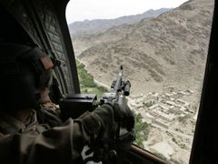 Voják NATO pátrá po tálibáncích z relativního bezpečí vojenské helikoptéry.