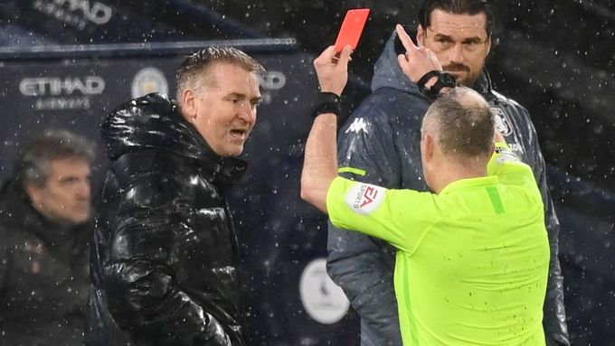 Dean Smith na lavičce Aston Villy dostává od rozhodčího Jonathana Mosse červenou kartu při utkání s Manchesterem City.
