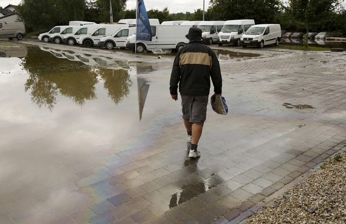 A man walks over the heating oil polluted car park of a car dealership after the floods of the Danube river subsided in Fischerdorf, a suburb of the eastern Bavarian city of Deggendorf June 10, 2013. Tens of thousands of people have been forced to leave their homes and there have been at least a dozen deaths as a result of floods that have hit Germany, Austria, Slovakia, Poland and the Czech Republic over the past week. REUTERS/Wolfgang Rattay (GERMANY - Tags: DISASTER TRANSPORT)