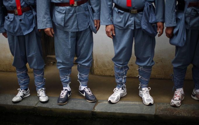 Mid-level government official dressed in red army uniforms wear sports shoes as they visit an old house where former Chinese leader Mao Zedong used to live, during a five-day training course at the communist party school called China Executive Leadership Academy of Jinggangshan, in Jiangxi province September 21, 2012. China Executive Leadership Academy was established in 2005 by the Central Committee of the Communist Party of China, after the 16th Communist Party Congress in 2002. By the end of August 2012, the academy has held 789 training classes for almost 40,000 people. During the course, trainees listen and sing revolutionary songs, visit old revolutionary sites and review historical communist materials. China has yet to announce the starting date for the 18th Communist Party Congress, China's biggest political meeting in a decade, which will see the transfer of power from President Hu Jintao and Premier Wen Jiabao to a new generation. REUTERS/Carlos Barria (CHINA - Tags: POLITICS SOCIETY) Published: Zář. 21, 2012, 3:43 odp.