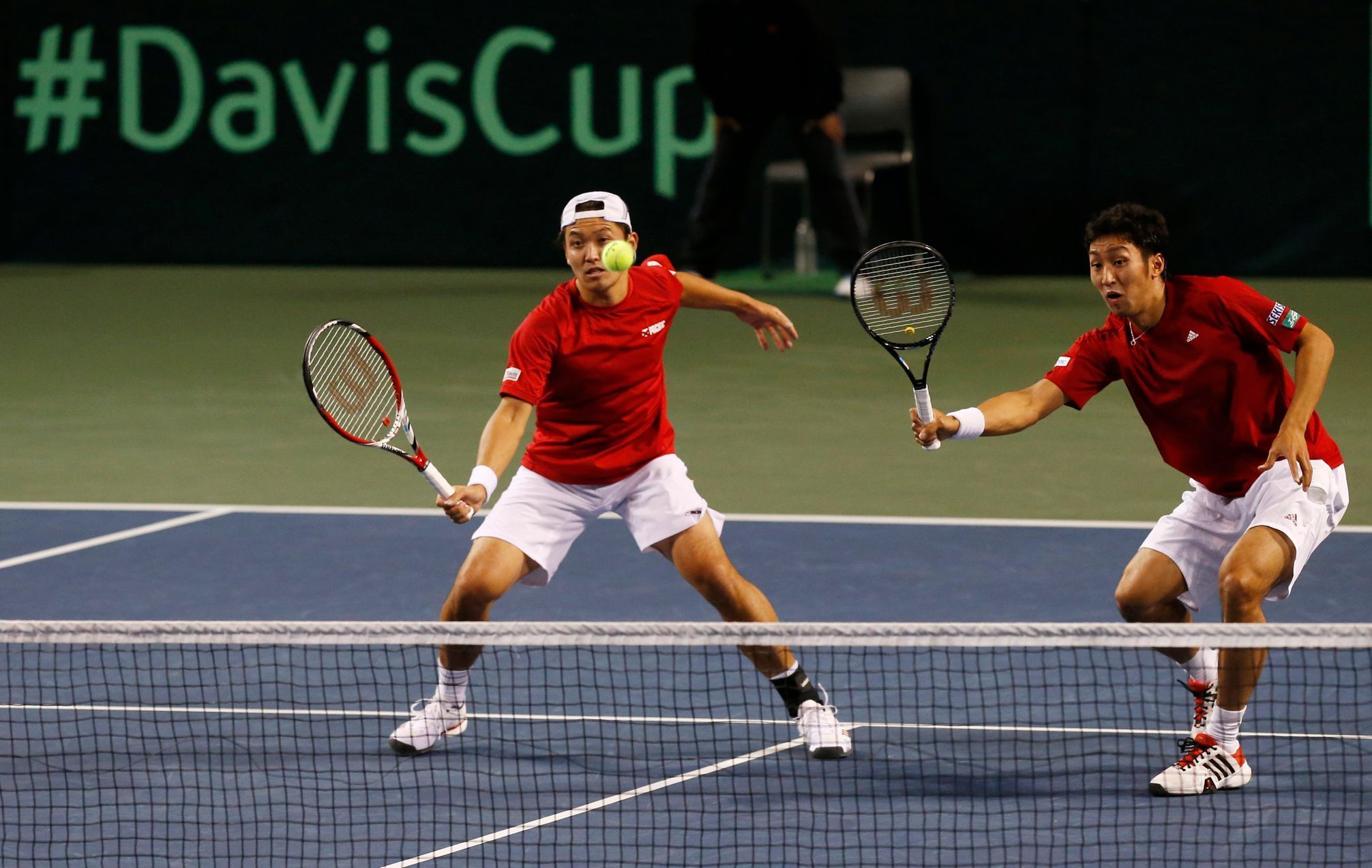 Japan's Uchiyama hits a return beside his compatriot Ito during their Davis Cup quarter-final men's doubles tennis match against Czech Republic's Stepanek and Rosol in Tokyo