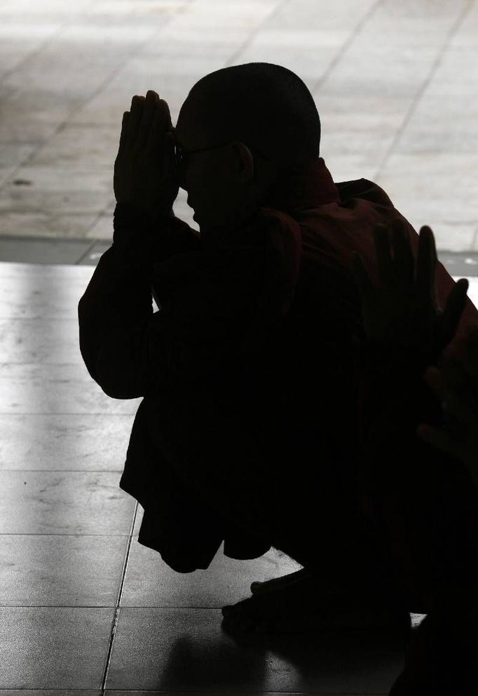 Buddhistický mnich během modlitby v rangúnské pagodě Shwedagon