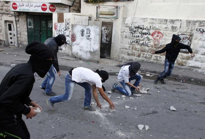 Palestinians throw stones at Israeli security forces (unseen) during clashes in protest to Israel's military operation in Gaza, in the East Jerusalem neighbourhood of Issawiya November 15, 2012. A Hamas rocket killed three Israelis north of the Gaza Strip on Thursday, drawing the first blood from Israel as the Palestinian death toll rose to 15 in a military showdown lurching closer to all-out war and an invasion of the enclave. REUTERS/Ammar Awad (JERUSALEM - Tags: POLITICS CIVIL UNREST) Published: Lis. 15, 2012, 5:32 odp.