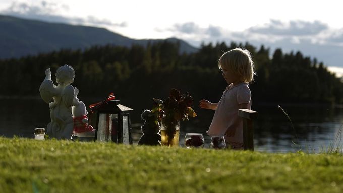 Dítě stojí u pietního místa nedaleko ostrova Utoya v Norsku.