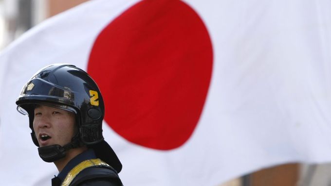 Japonský policista před státní vlajkou při nedávném protestu nacionalistů v Tokiu. I v souvislosti s posledním incidentem na Okinawě se dají očekávat podobné akce