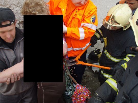 Hasiči vyprošťují ženu, která se po pádu ze schodů nabodla na plot