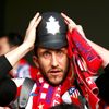 An Atletico Madrid fan wears a tradtional English policemen's helmet before the Champions League semi-final second leg soccer match between Chelsea and Atletico Madrid at Stamford Bridge Stadium in Lo