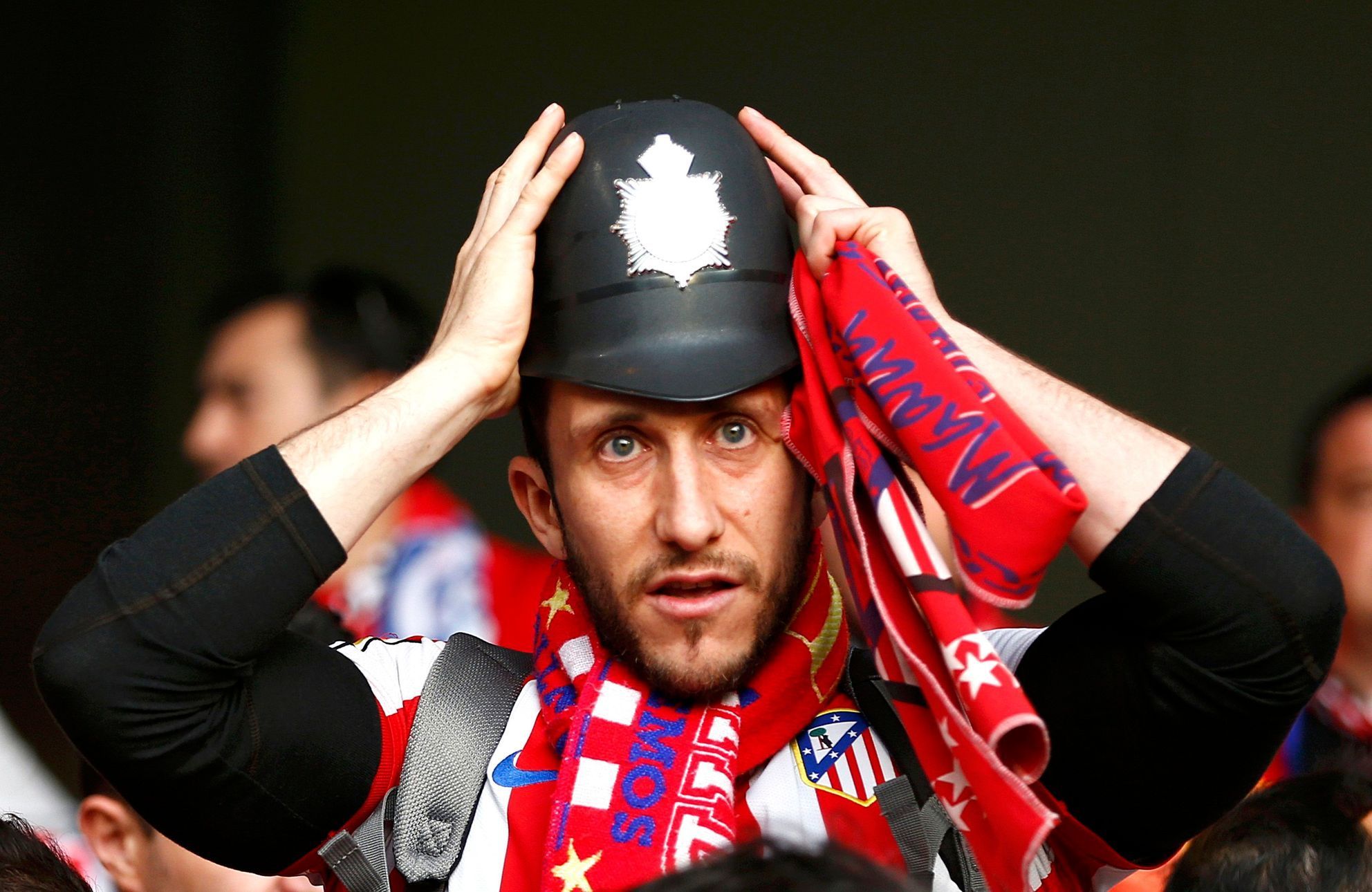 An Atletico Madrid fan wears a tradtional English policemen's helmet before the Champions League semi-final second leg soccer match between Chelsea and Atletico Madrid at Stamford Bridge Stadium in Lo
