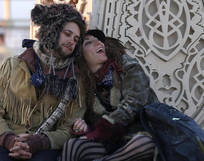 Steven Babson (L) and Lila Wright sit at the Temple of Juno at sunrise during the Burning Man 2012 "Fertility 2.0" arts and music festival in the Black Rock Desert of Nevada, August 29, 2012. More than 60,000 people from all over the world have gathered at the sold out festival, which is celebrating its 26th year, to spend a week in the remote desert cut off from much of the outside world to experience art, music and the unique community that develops.