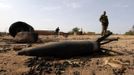 A Malian soldier is seen near an unexploded shell in the recently liberated town of Konna January 26, 2013. REUTERS/Eric Gaillard (MALI - Tags: CIVIL UNREST CONFLICT MILITARY TPX IMAGES OF THE DAY) Published: Led. 26, 2013, 8:05 odp.