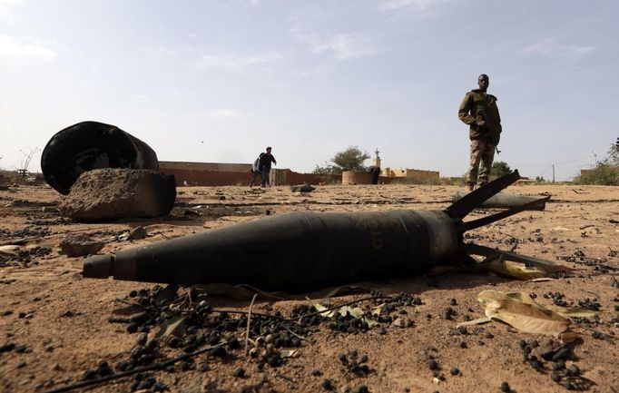 A Malian soldier is seen near an unexploded shell in the recently liberated town of Konna January 26, 2013. REUTERS/Eric Gaillard (MALI - Tags: CIVIL UNREST CONFLICT MILITARY TPX IMAGES OF THE DAY) Published: Led. 26, 2013, 8:05 odp.