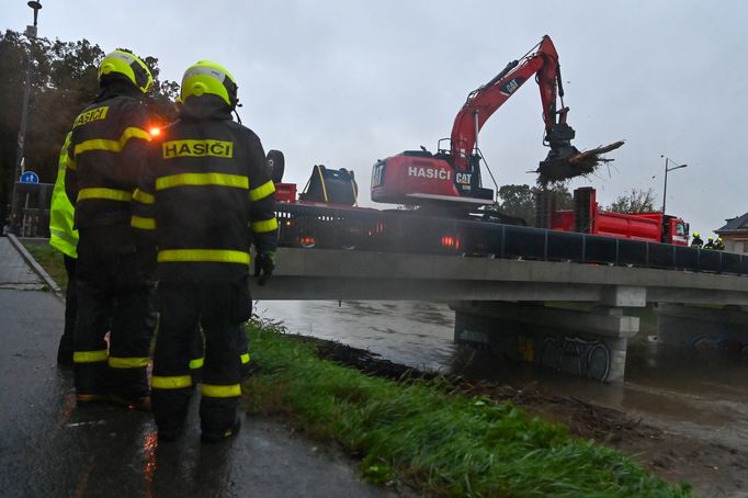 Hasiči v Opavě-Kateřinkách vytahují z řeky Opavy naplavené dřevo.