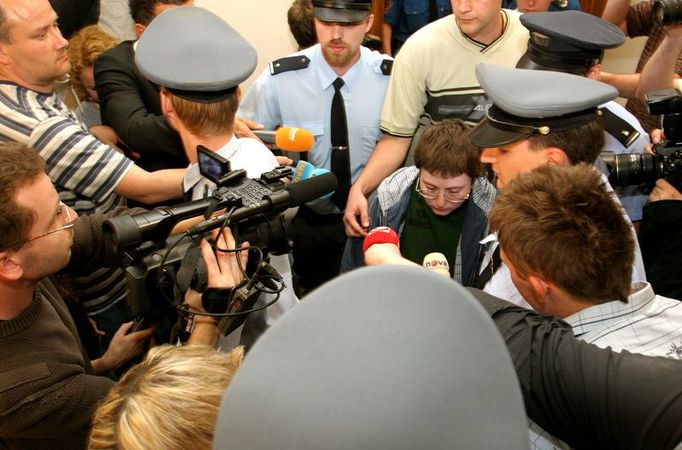 Barbora Škrlová vychází v doprovodu policistů ze soudní síně.