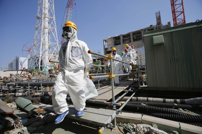 Members of the media wearing protective suits and masks are escorted by TEPCO employees to the Common Pool Building for spent fuel pool, where the nuclear fuel rods will be stored for decommissioning, as they visit at Tokyo Electric Power Co. (TEPCO)'s tsunami-crippled Fukushima Daiichi nuclear power plant in Fukushima prefecture, March 6, 2013, ahead of the second-year of anniversary of the March 11, 2011 tsunami and earthquake. Members of the media were allowed into the plant on Wednesday ahead of the second-year anniversary of the March 11, 2011 tsunami and earthquake, which triggered the world's worst nuclear crisis since Chernobyl. REUTERS/Issei Kato (JAPAN - Tags: DISASTER ANNIVERSARY ENERGY) Published: Bře. 6, 2013, 9:09 dop.