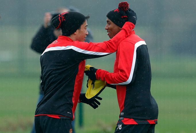 Manchester United's Kagawa hugs teammate Young during a training session at the club's Carrington training complex in Manchester