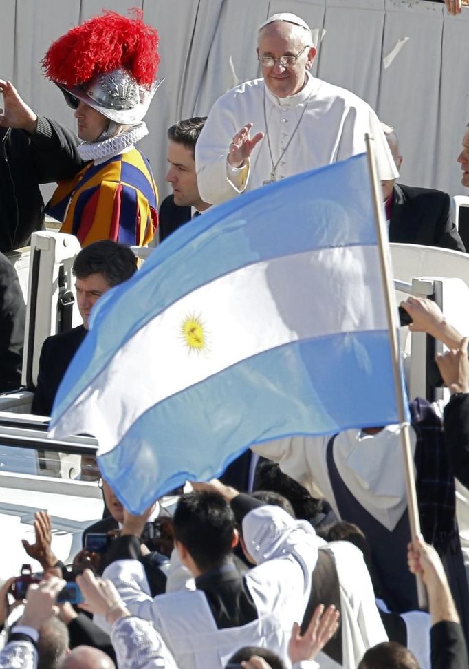 Pope Francis approaches priests with an Argentine flag as he arrives in Saint Peter's Square for his inaugural mass at the Vatican, March 19, 2013. Pope Francis celebrates his inaugural mass on Tuesday among political and religious leaders from around the world and amid a wave of hope for a renewal of the scandal-plagued Roman Catholic Church. REUTERS/Stefano Rellandini (VATICAN - Tags: RELIGION POLITICS) Published: Bře. 19, 2013, 8:26 dop.