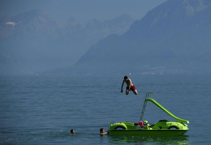 A young man jumps from a pedalo into the water of Lake Leman as he and his friends enjoy a hot summer day in Lausanne August 17, 2012. The Federal Office of Meteorology MeteoSwiss has launched a warning for a heat wave for the weekend until Wednesday August 22. REUTERS/Denis Balibouse (SWITZERLAND - Tags: ENVIRONMENT TPX IMAGES OF THE DAY SOCIETY) Published: Srp. 17, 2012, 2:26 odp.