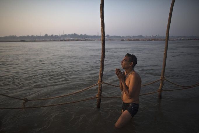 A Hindu devotee prays as he takes a dip in the waters of the holy Ganges river ahead of the "Kumbh Mela" (Pitcher Festival) in the northern Indian city of Allahabad January 11, 2013. During the festival, Hindus take part in a religious gathering on the banks of the river Ganges. "Kumbh Mela" will return to Allahabad in 12 years. REUTERS/Ahmad Masood (INDIA - Tags: RELIGION) Published: Led. 11, 2013, 10:02 dop.