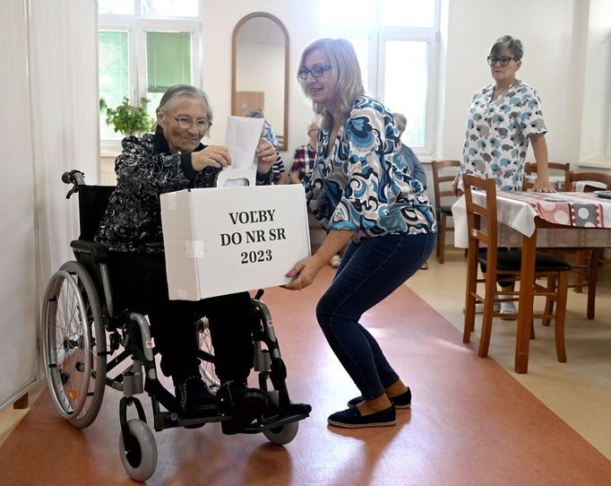 Volička vhazuje obálku s hlasovacím lístkem do přenosné volební schránky v zařízení pečovatelské služby Prameň nádeje v Trebišově.