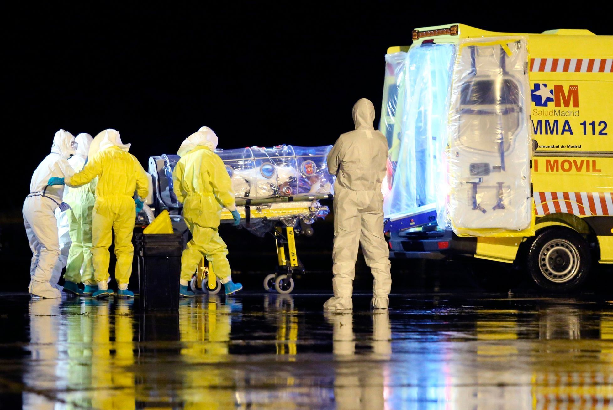 Zdravotníci nakládají španělského kněze nakaženého ebolou do sanitky.