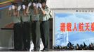 Soldiers adjust their caps while standing guard at an entrance of the Wentiange, Chinese astronauts' apartment building, in Jiuquan Satellite Launch Center, Gansu province, June 16, 2012. China will send its first woman into outer space this week, prompting a surge of national pride as the rising power takes its latest step towards putting a space station in orbit within the decade. Liu Yang, a 33-year-old fighter pilot, will join two other astronauts aboard the Shenzhou 9 spacecraft when it lifts off from a remote Gobi Desert launch site on Saturday evening. REUTERS/Jason Lee (CHINA - Tags: SCIENCE TECHNOLOGY MILITARY) Published: Čer. 16, 2012, 2:36 dop.