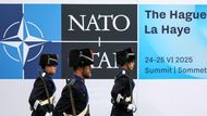 Jsme připraveni. Příslušníci armády v slavnostních uniformách pochodují kolem loga NATO v den summitu aliančních lídrů v Haagu.