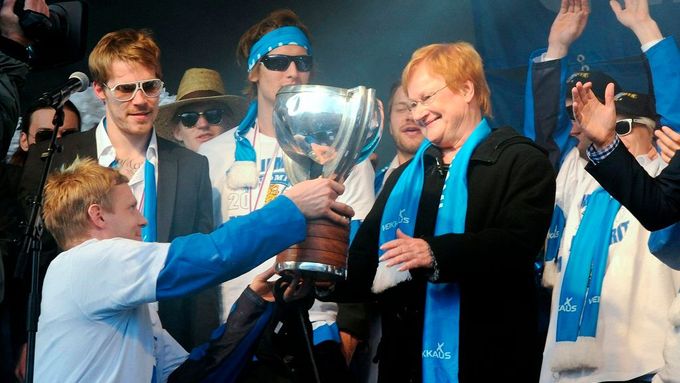 Finský kapitán Mikko Koivu předává pohár prezidentce Tarje Halonenové.