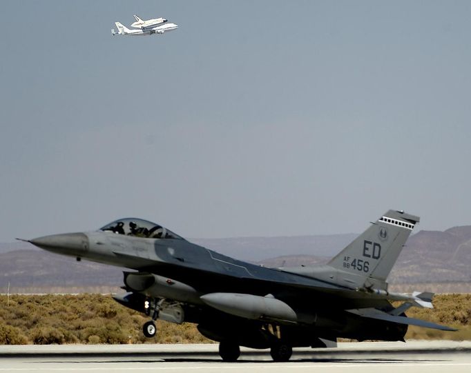 An F-16 fighter jet is seen in the foreground as the space shuttle Endeavour makes a flyby before landing at Edwards Air Force Base in California, September 20, 2012. REUTERS/Gene Blevins (UNITED STATES - Tags: SCIENCE TECHNOLOGY MILITARY SOCIETY TRANSPORT) Published: Zář. 20, 2012, 10:12 odp.