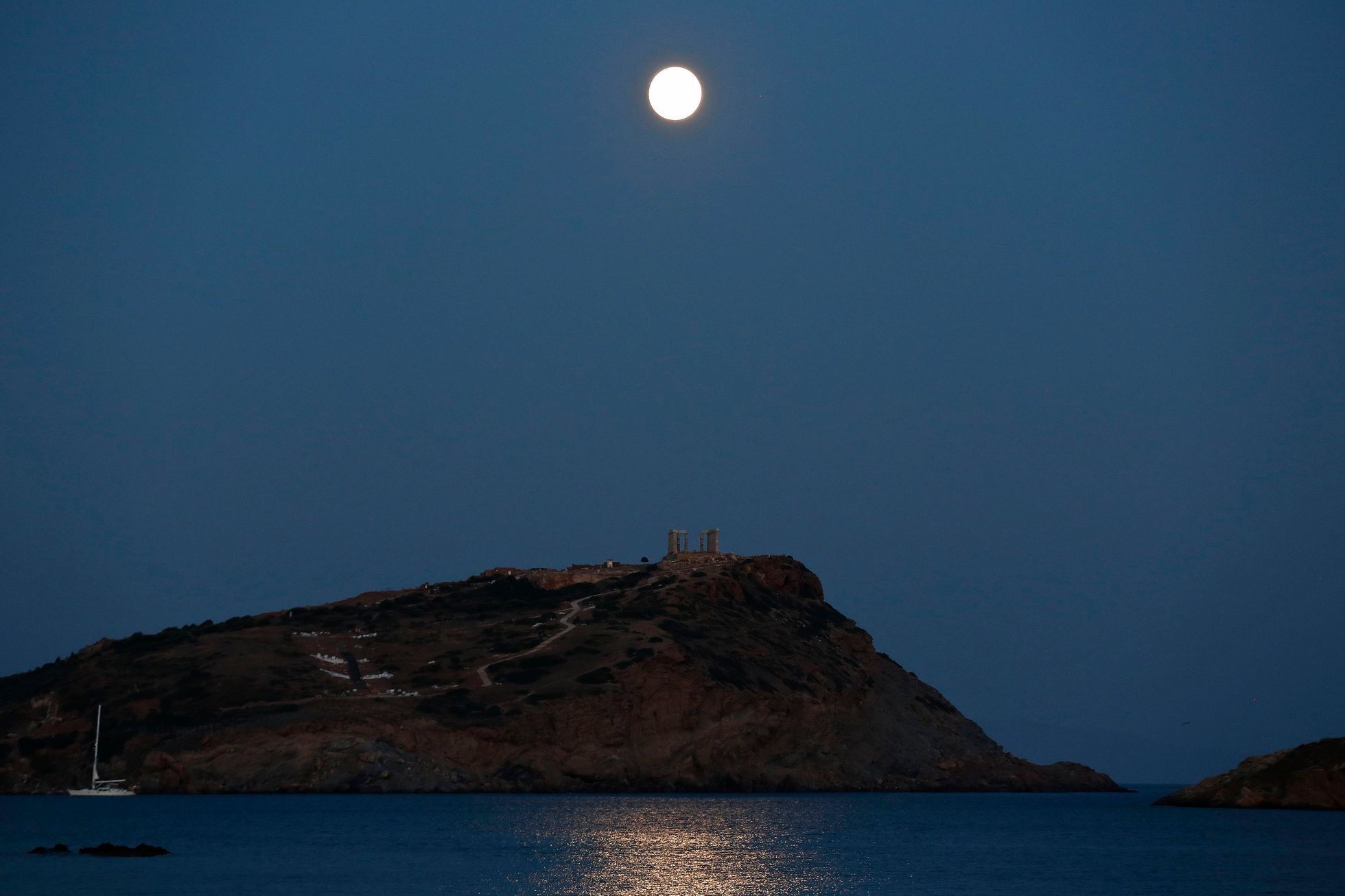 The supermoon rises over the Temple of Poseidon in Cape Sounion, east of Athens