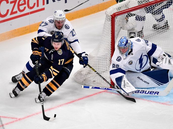 Vladimír Sobotka z Buffala (17) a hráči Tampy Bay Ryan McDonagh a Andrei Vasilevský v zápase NHL.