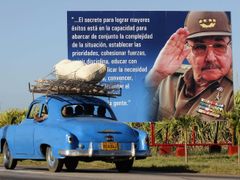 Řidič míjí billboard s kubánským prezidentem Raúlem Castro. Momentka z okolí Havany, 29. února 2012.