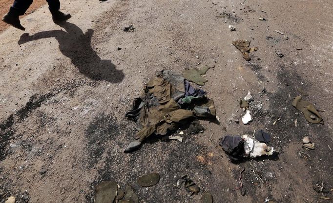 A Malian soldier walks past burnt uniforms in the recently liberated town of Konna January 26, 2013. REUTERS/Eric Gaillard (MALI - Tags: CIVIL UNREST CONFLICT MILITARY POLITICS) Published: Led. 26, 2013, 3:18 odp.