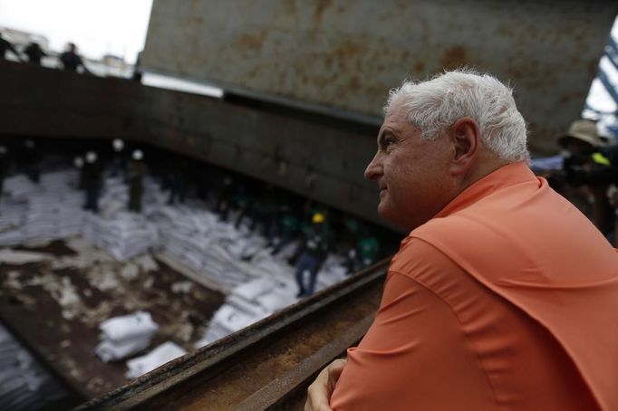 Panama's President Ricardo Martinelli look at bags labeled "Cuban Raw Sugar" inside a North Korean flagged ship "Chong Chon Gang" docked at the Manzanillo Container Terminal in Colon City July 16, 2013. Panama detained the North Korean-flagged ship from Cuba as it headed to the Panama Canal and said it was hiding weapons in brown sugar containers, sparking a standoff in which the ship's captain attempted to commit suicide. Martinelli said the undeclared weapons were detected inside the containers when Panamanian authorities stopped the ship, suspecting it was carrying drugs. REUTERS/Carlos Jasso (PANAMA - Tags: CRIME LAW DRUGS SOCIETY POLITICS) Published: Čec. 16, 2013, 9:15 odp.