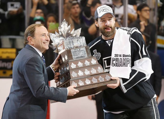 Los Angeles Kings' Justin Williams (R) is presented with the Conn Smythe trophy as the Most Valuable Player from NHL Commissioner Gary Bettman after Game 5 of their NHL S