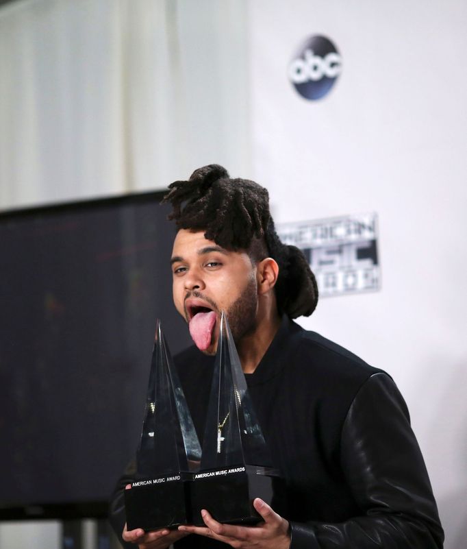 poses with his aThe Weekndwards during the 2015 American Music Awards in Los Angeles