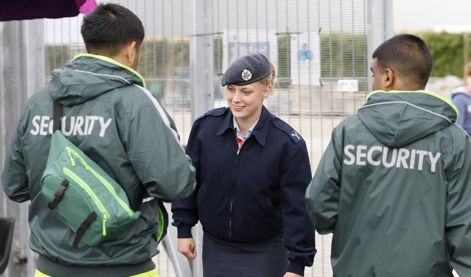 A member of the RAF checks the identifications of two G4S security guards at an exit to the Olympic Park in Stratford, the location of the London 2012 Olympic Games, in east London July 15, 2012. The head of private security firm G4S said on Saturday his firm only realised just over a week ago it would not be able to supply enough venue guards for this month's London Olympics, as he publicly apologised for the embarrassing failure. On Thursday, the government said it would deploy additional troops after it became clear G4S was unlikely to provide the expected 10,400 guards it was contracted to do because of problems processing applicants. REUTERS/Andrew Winning (BRITAIN - Tags: MILITARY POLITICS SOCIETY SPORT OLYMPICS) Published: Čec. 15, 2012, 2:13 odp.