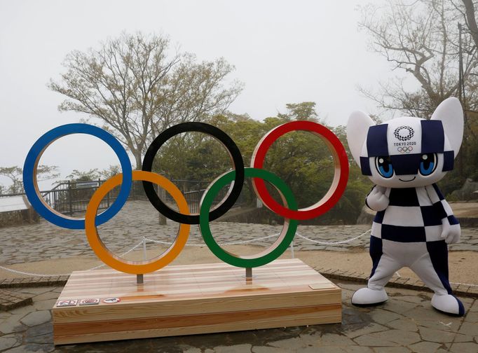 FILE PHOTO: Tokyo 2020 Olympic Games mascot Miraitowa poses with  a display of the Olympic symbol after an unveiling ceremony of the symbol on Mt. Takao in Hachioji, west