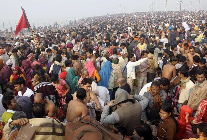 Hindu devotees get dressed after taking dip during the first "Shahi Snan" (grand bath) at the ongoing "Kumbh Mela", or Pitcher Festival, in the northern Indian city of Allahabad January 14, 2013. Upwards of a million elated Hindu holy men and pilgrims took a bracing plunge in India's sacred Ganges river to wash away lifetimes of sins on Monday, in a raucous start to an ever-growing religious gathering that is already the world's largest. REUTERS/Jitendra Prakash (INDIA - Tags: RELIGION SOCIETY) Published: Led. 14, 2013, 12:06 odp.