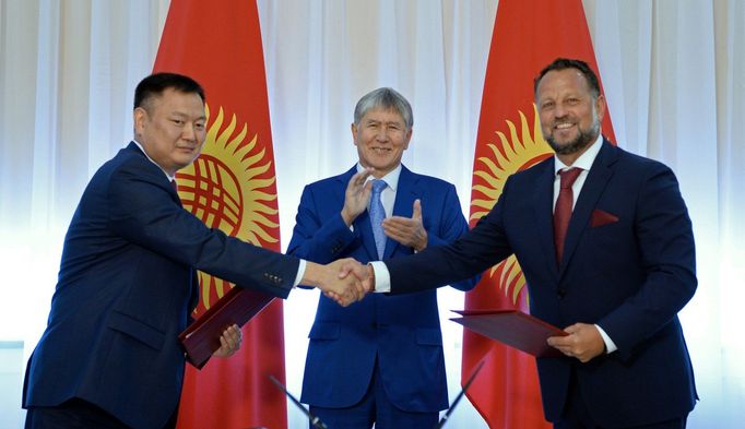 Michael Smelík si podává ruku se zástupcem kyrgyzské vlády. Tleská jim prezident Almazbek Atambajev.