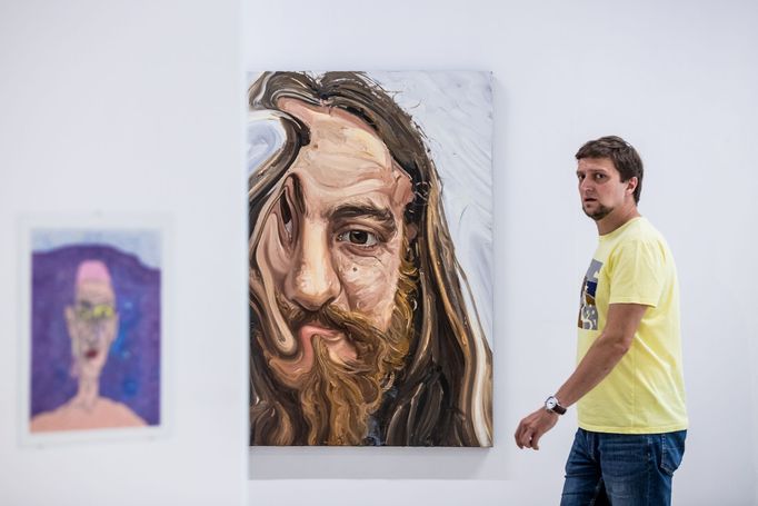 Na snímku je kurátor výstavy Pavel Dvořák vedle obrazu z cyklu Laďa od Hynka Martince.