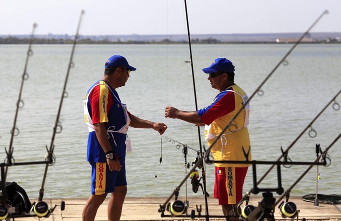 Valeriu Martoiu (L) and Ionel Ghelase (R) of Romania discuss during the 14th Carpfishing World Championship in Corbu village, 310 km (192 miles) east of Bucharest, September 29, 2012. REUTERS/Radu Sigheti (ROMANIA - Tags: SOCIETY) Published: Zář. 29, 2012, 4:34 odp.